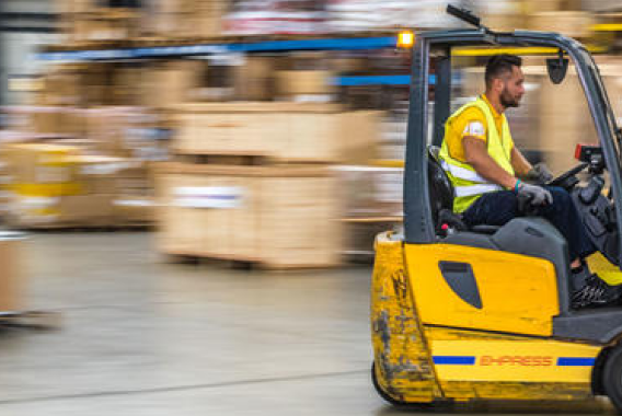 Yellow forklift driving through a warehouse