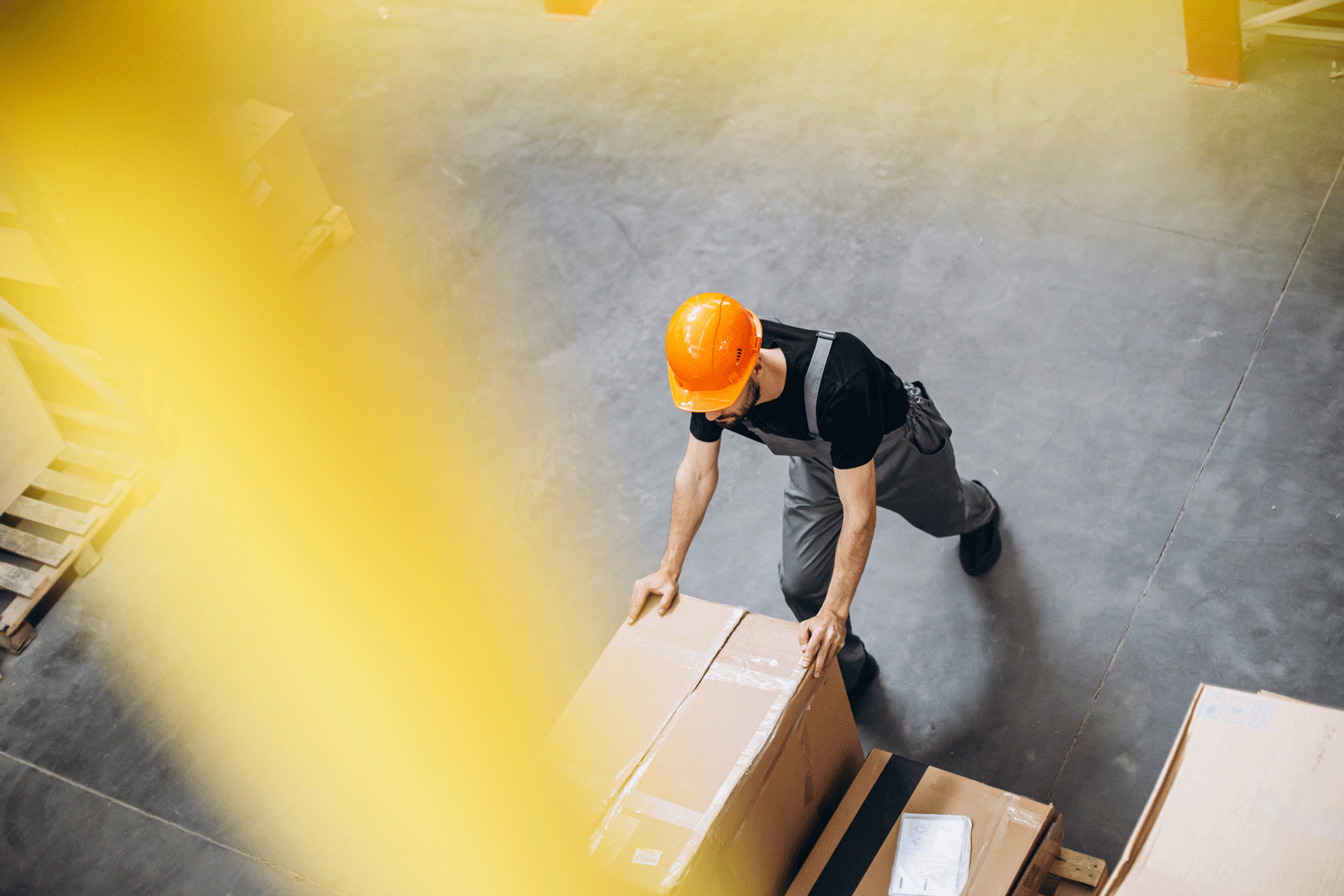 Person pushing boxes in a warehouse